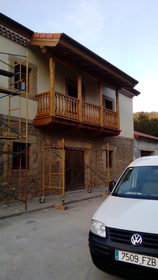 Balconada asturiana de madera en fachada de piedra