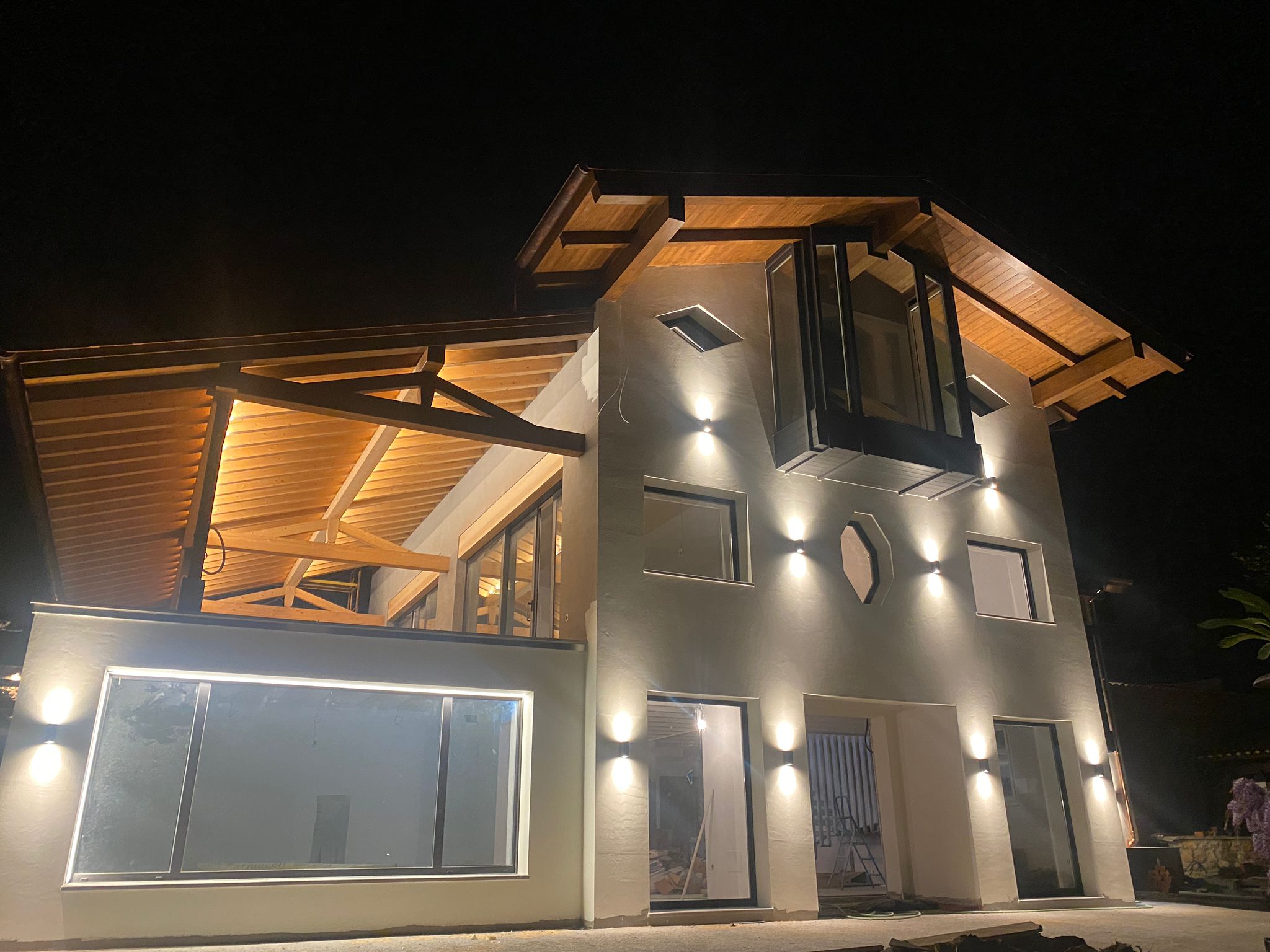 Casa moderna con estructura de madera iluminada de noche