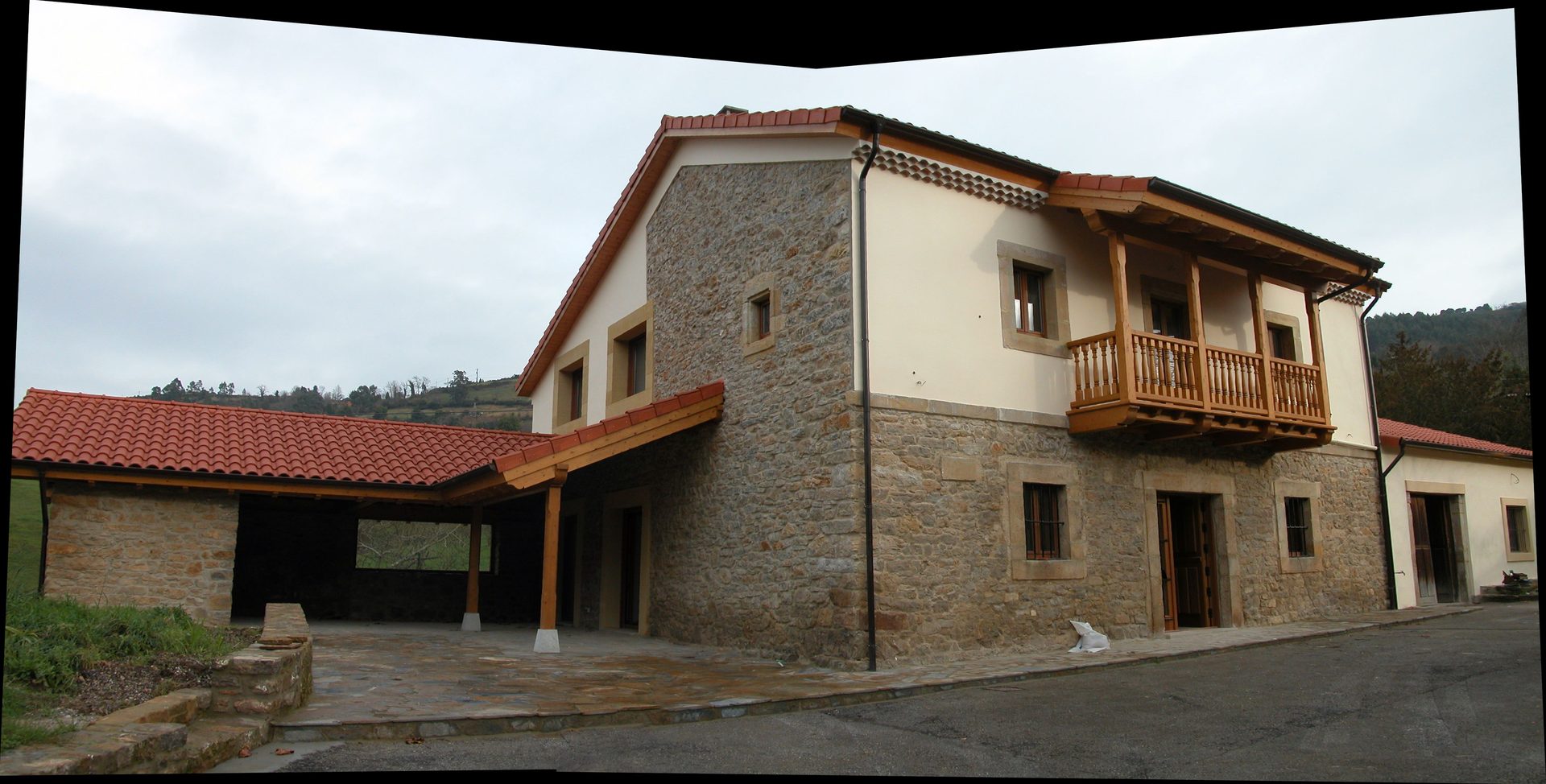 Casa de piedra con porche y tejado de madera en Asturias