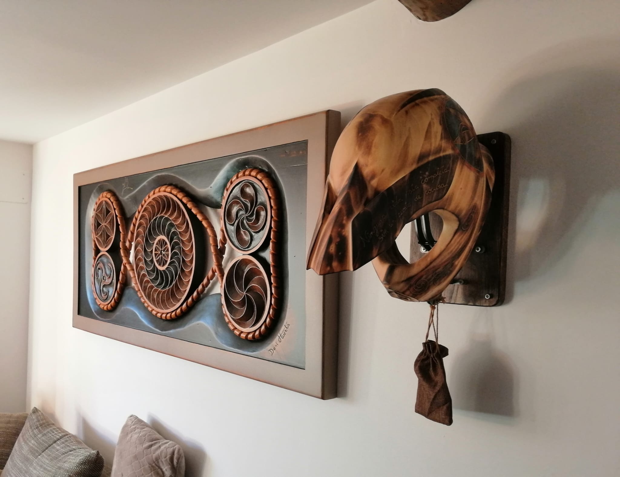 Cuadro con trisqueles y máscara tallados en madera