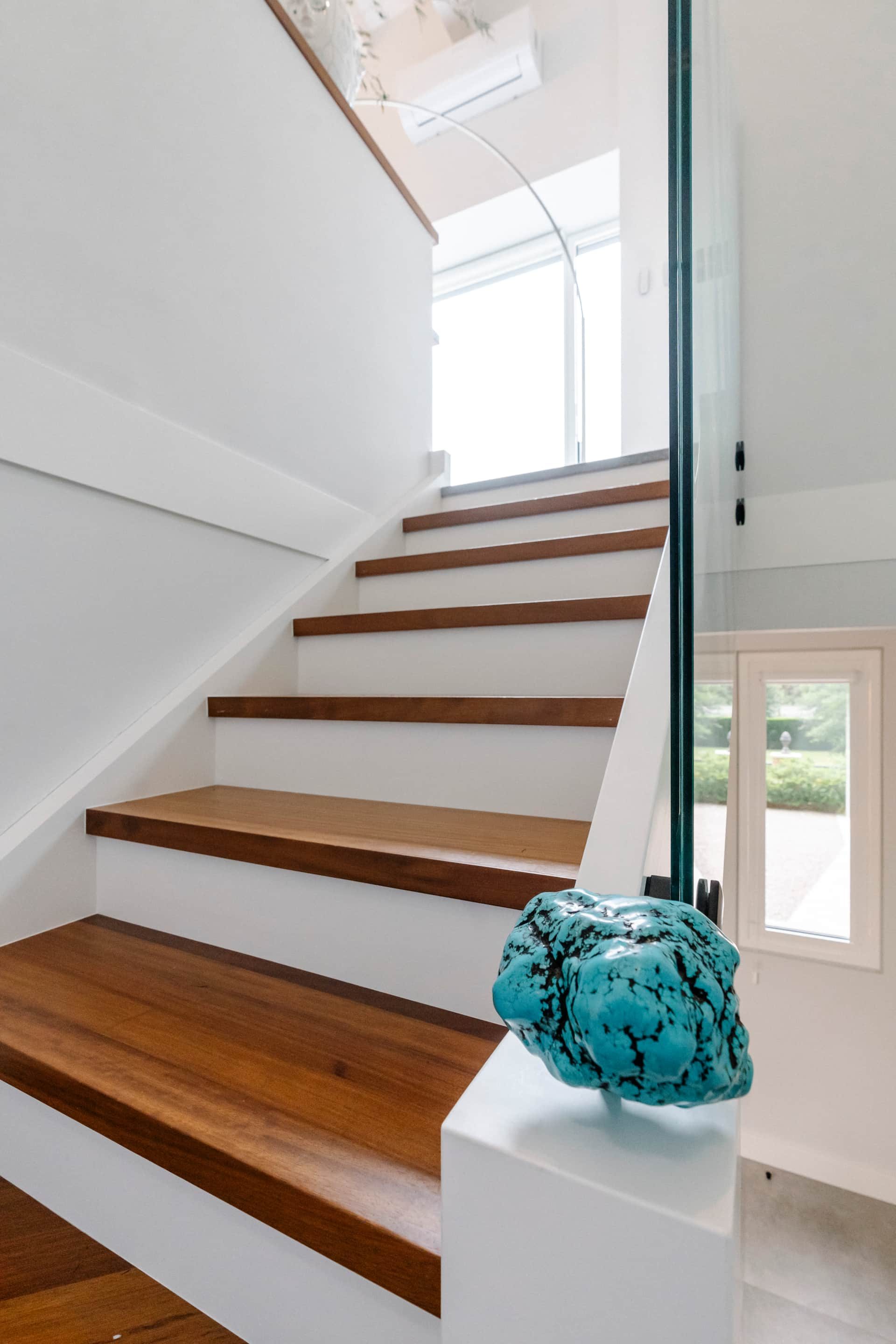 Escalera interior con peldaños de madera y cristal