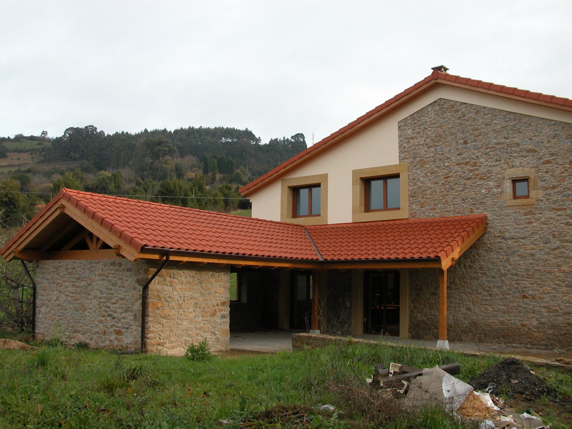 Mesa y bancos artesanos en salón rústico con chimenea