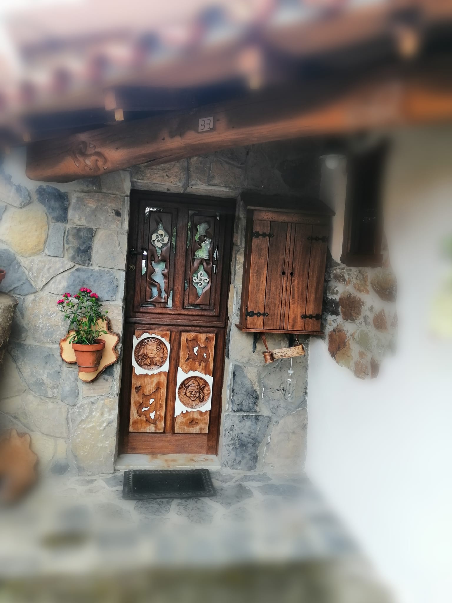 Puerta artesana tallada con motivos asturianos tradicionales